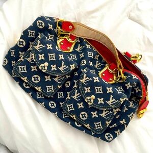 Denim handbag with red leather accents.